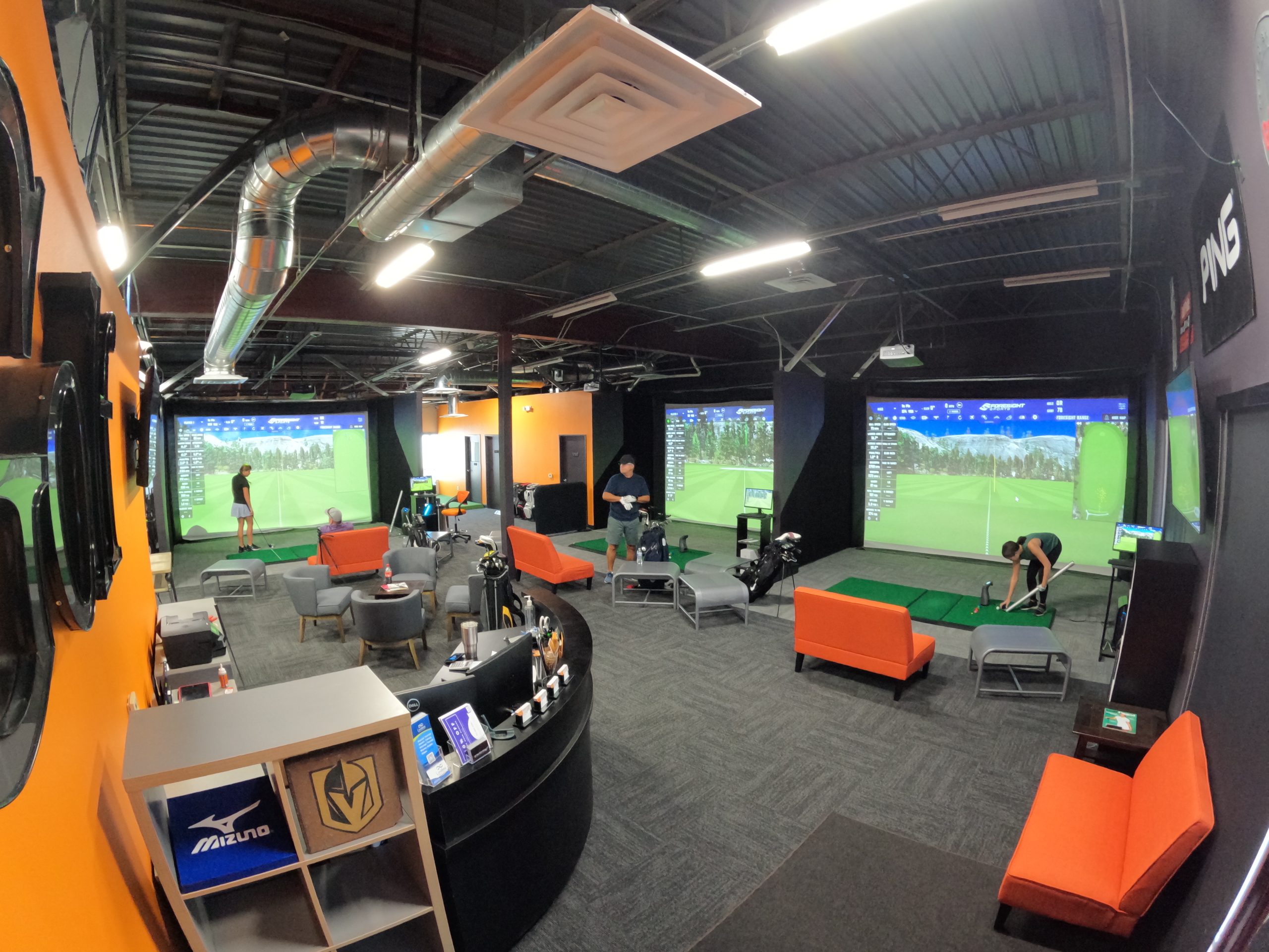 Wide view of indoor simulator bays and seating at RoboGolfPro Las Vegas