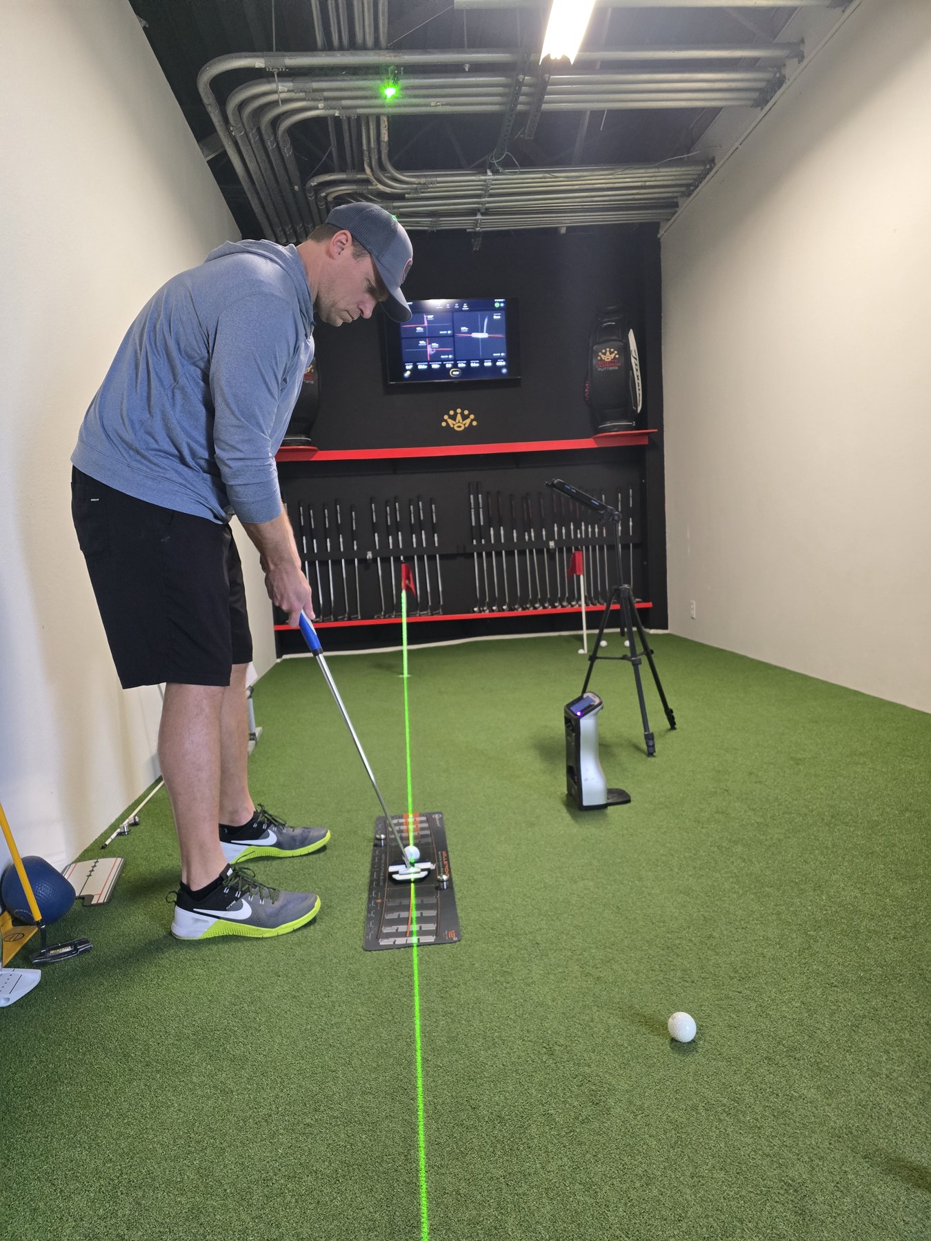 Golfer practicing putting with alignment and feedback equipment